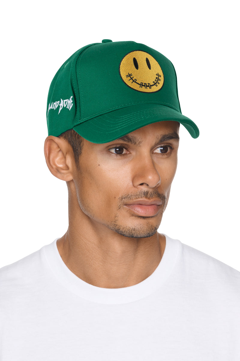 GORRA MONOCROMO VERDE DE ALGODÓN CEPILLADO CON CARITA SONRIENTE Y CIERRE A PRESIÓN